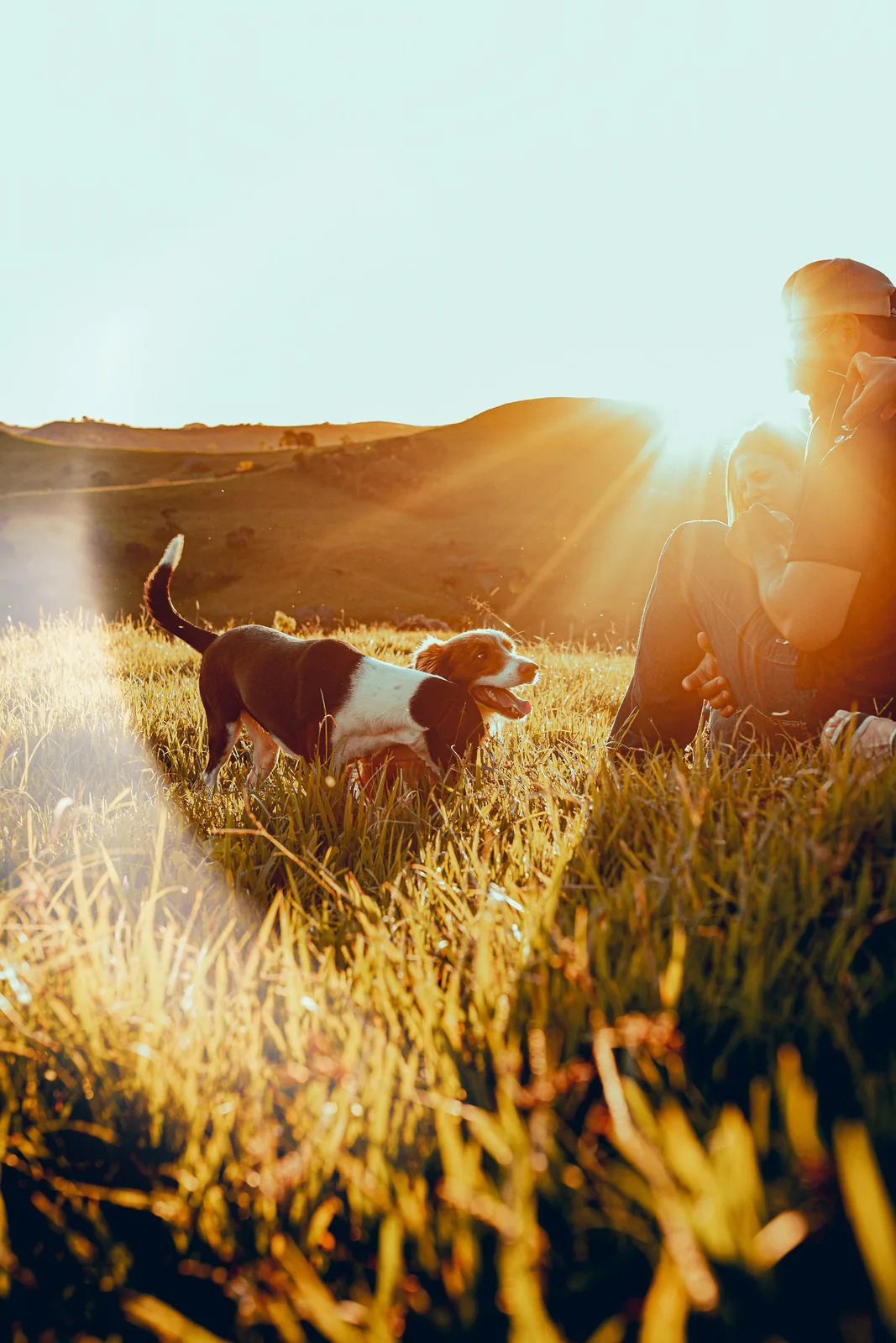 Two people outdoors with their dog